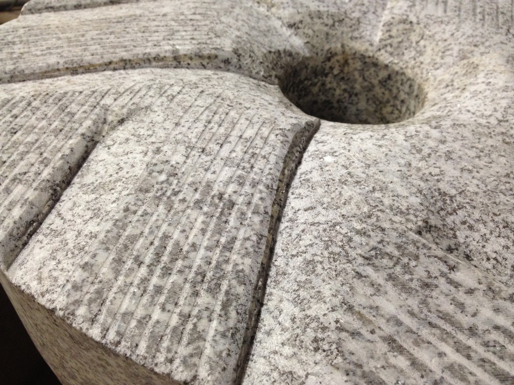 La meule de pierre se trouve sous les toits.